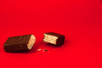 Sweets food concept, composition of slice chocolate waffle bars on a red background, flat lay, copy space