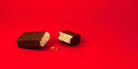 Sweets food concept, composition of slice chocolate waffle bars on a red background, flat lay, copy space, banner
