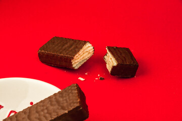 Sweets food concept, composition of slice chocolate waffle bars on a red background, flat lay, copy space, kitchen