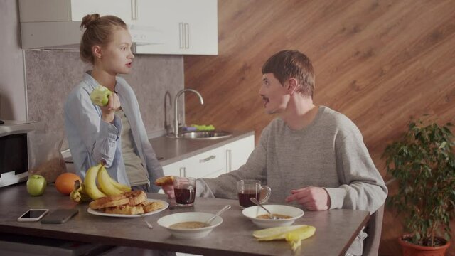 Domestic quarrel of the couple over a trifle in the kitchen. The husband drops the rag and leaves the table. My wife was offended. Family abuse and gender inequality.