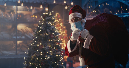 Santa Claus in mask walking quietly near Christmas tree