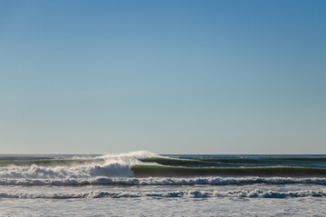 Big Waves break in the Pacific Ocean on a California beach