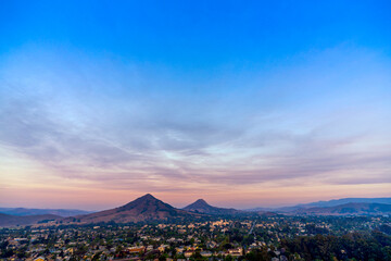 Magenta, pink sky at sunset over Hills, City, horizon