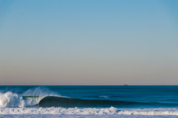Big Waves break in the Pacific Ocean on a California beach