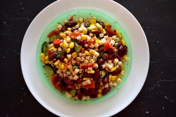 Homemade Mexican salad on a white plate with black background 