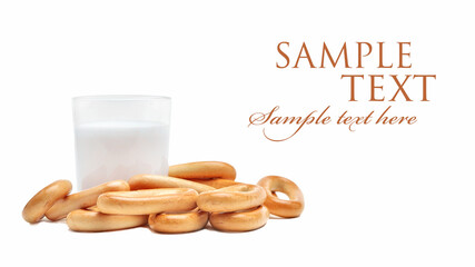 fresh bagels and a glass of milk next to each other on an isolated white background