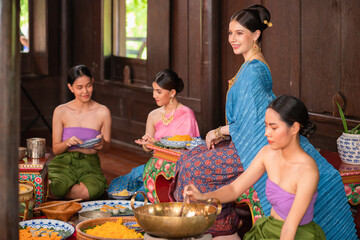 Beautiful Asian women in Thai, dressed in traditional Thai costumes and making desserts in the kitchen with the boss, her daughter and the servant. In the concept of life in the past of the Ayutthaya