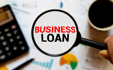 On the desktop, graphs, reports, a magnifying glass with the inscription BUSINESS LOAN.