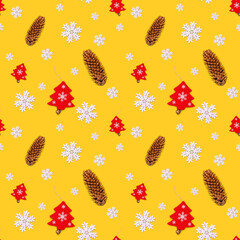 Seamless yellow background with Christmas decorations, white snowflakes, fir cones and a red wooden...