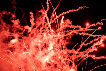 Shining fireworks with red smoke. Fireworks emitting sparks at night with dark background. New...