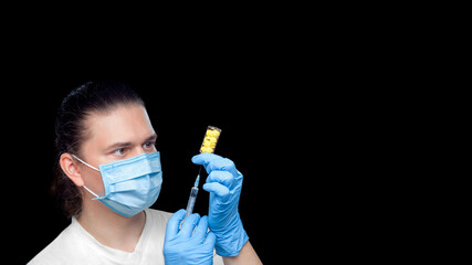 a virologist in protective mask and sterile gloves with a syringe in his hands is collecting...