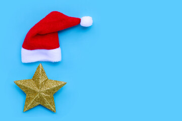 Golden star with santa hat on blue background. Copy space