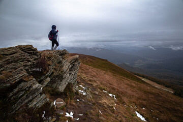Turystka podziwia g&oacute;rską panoramę podczas p&oacute;źnej jesieni stojąc na szczycie Połoniny Caryńskiej, Bieszczady, Polska
