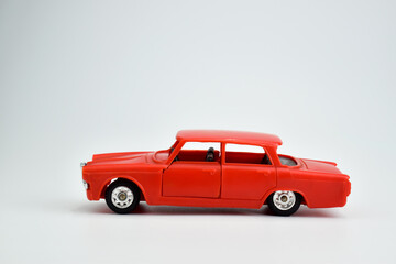 A red toy car stands on a white background. Toys for the boy. Plastic car.