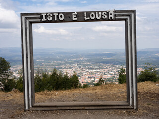 Wooden frame on a viewpoint over the portuguese village Lousã. It says "This is Lousã".