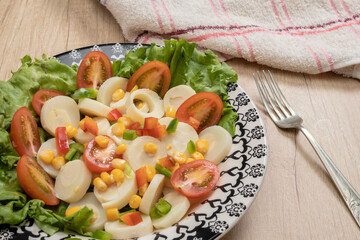 Fresh and exquisite salad of palm hearts cut into slices, cherry tomatoes, corn kernels, red...