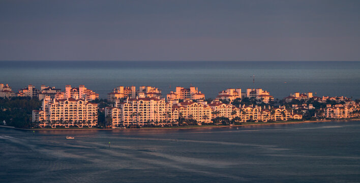 Island homes at dusk in the middle of the ocean with warm tones kissing the facade