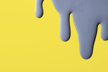 Smears of Ultimate Gray paint on a yellow background Illuminating trending colors of 2021