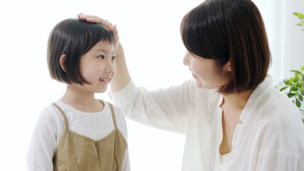 女の子の頭を撫でるお母さん