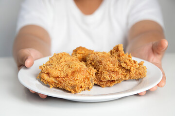 Asian fat boy eats fried chicken Wear a white shirt. Concepts of child health problems Pathogenic food