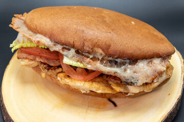 Mexican bun sandwich Torta perfectly prepared Hawaiian style on the grill stacked with cheese, veggies and meat.
