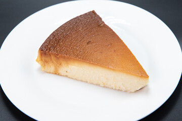 Delicately prepared Mexican Flan sweet and savory dessert alone on a white plate