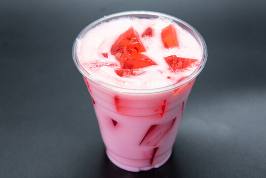 Suspended chunks of jello in a chilled dessert served in an easy to carry cup for sweets on the go.