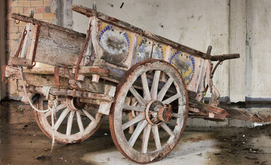 Fototapeta na wymiar Antico carro agricolo da buoi dipinto a mano in stato di abbandono