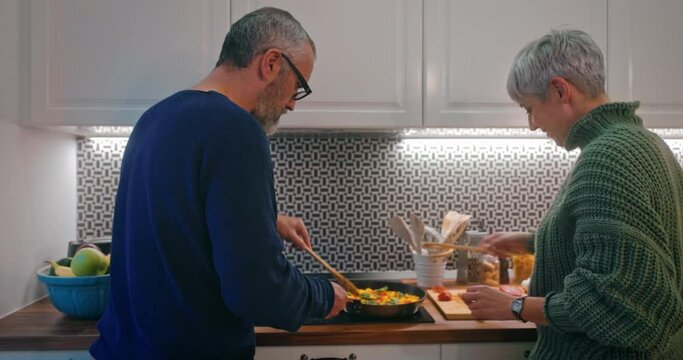 Senior couple preparing dinner together in the kitchen