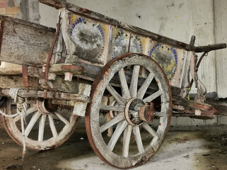 Fototapeta na wymiar Antico carro agricolo da buoi dipinto a mano in stato di abbandono