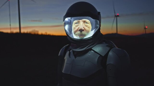 Portrait view of the astronaut looking at the camera on the new planet, while walking in the middle of field to explore the new world and live there. Concept: success, dreams, astronaut, inspiration