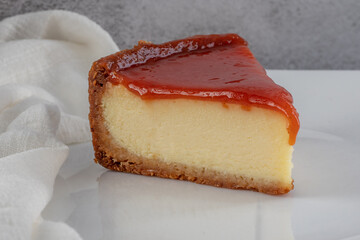 slice of cheesecake with guava paste on a white plate on gray and blue background