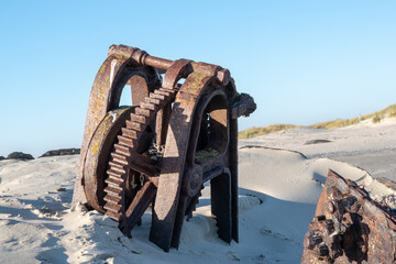 Selective focus shot of a shipwreck on a sandy beach in Norderney, Germany