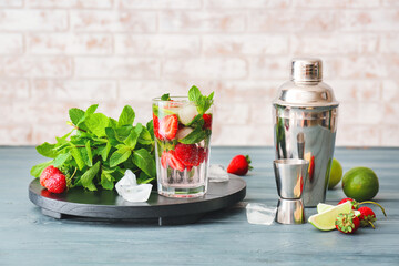 Glass of tasty strawberry mojito on table