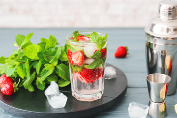 Glass of tasty strawberry mojito on table