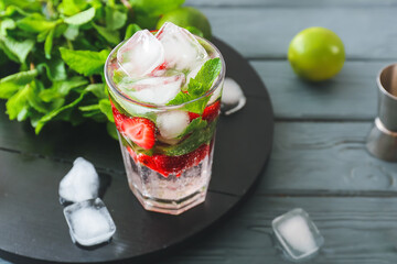 Glass of fresh strawberry mojito on table