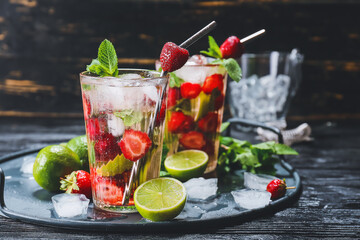 Glasses of fresh strawberry mojito on table
