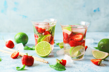 Glasses of fresh strawberry mojito on table