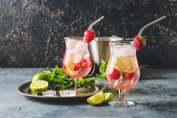 Glasses of fresh strawberry mojito on dark background