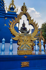 Fototapeta na wymiar Black giant statue holding a blue crystal ball inside a Rong Suea Ten temple in Thailand. (blue temple).