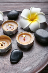 Candles, stones and flower on wooden background