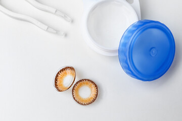 Contact lenses with container and tweezers on white background