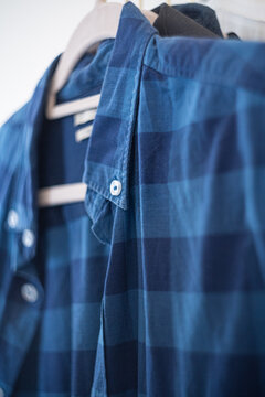 Vertical shot of a blue flannel shirt with white buttons
