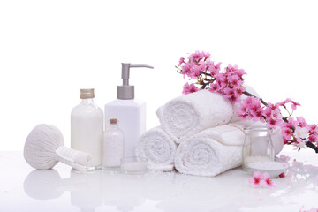 Spa setting with Sakura cherry blossom , rolled towel ,oil ,salt in bottle, compressing herbal ball ,


