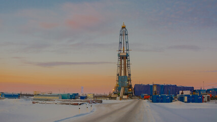 Winter landscape of a snowy forest tundra with a drilling rig for drilling an oil and gas well in...