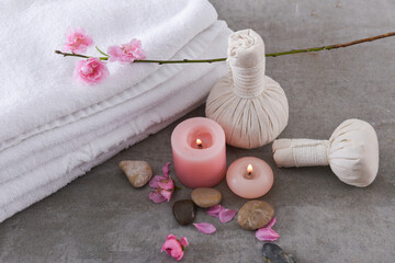 Fototapeta na wymiar Set of Sakura cherry blossom , candle, salt in bowl with compressing herbal ball on gray background