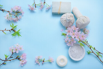 Set of Sakura cherry blossom , candle, salt in bowl with compressing herbal ball on blue background