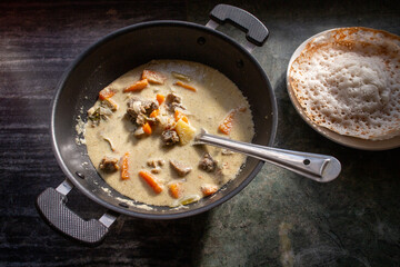 Mutton stew , chicken stew soup side dish Appam , bread, Kerala breakfast food India Sri Lanka Christian Christmas food. spicy curry prepared with coconut milk, vegetables ,meat, Indian spices.