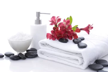 Tuinposter spa concept with stones,red flowers on towel with essential oils    © Mee Ting