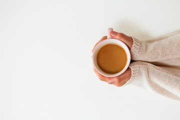 Female hands holding cups of coffee on white table background